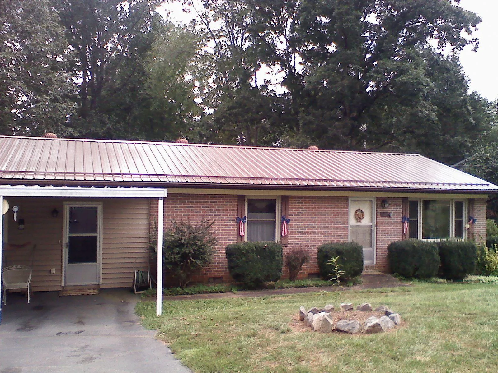 Bronze metal roof and carport on a brick ranch home — Roof Repair work by our crew in Pennington